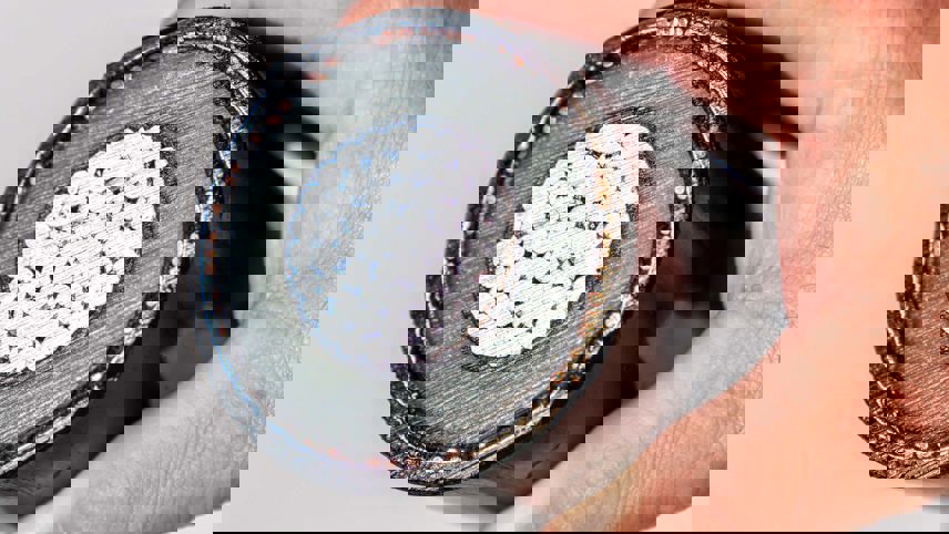 Hand holding the cross-section of a power cable showing conductor, insulation and sheath.