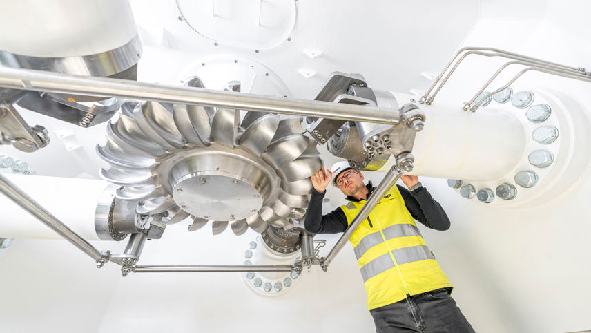 Engineer inspects a turbine runner inside a power plant.