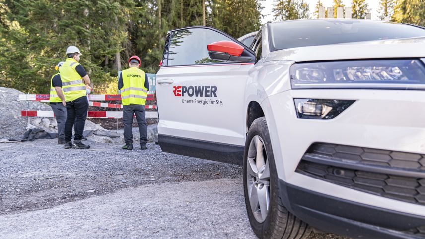 Repower team at a construction site; company vehicle nearby, staff wearing safety vests.